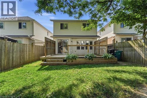 Rear exterior featuring a tiered wooden deck with integrated planter boxes, privacy wood fencing, and a grass lawn - 449 Exmoor Street, Waterloo, ON 