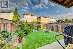 Rear yard featuring a concrete patio, lawn area, and perimeter wood fencing with lattice detailing - 