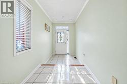 Foyer featuring white ceramic tile flooring, recessed lighting, and an entry door with decorative glass inlay and matching sidelight - 