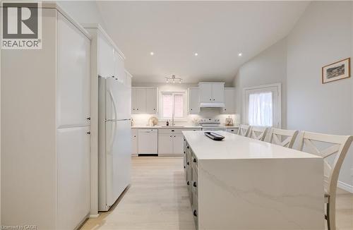 Kitchen featuring white cabinetry, light wood-finish flooring, a central island with a light-toned countertop, and recessed lighting - 245 Fern Crescent, Waterloo, ON 