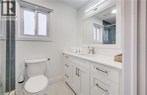 White vanity with shaker-style cabinetry, a single basin sink, and a rectangular mirror with integrated lighting - 245 Fern Crescent, Waterloo, ON 