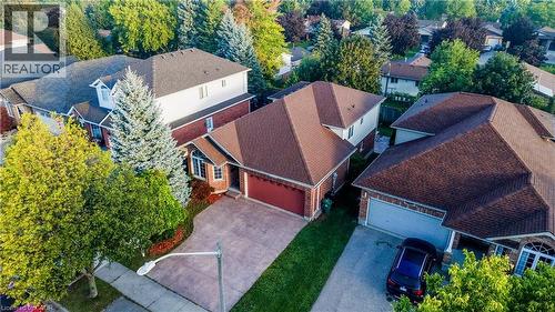 Brick exterior residence with a two-car garage, mature landscaping, and a paved driveway - 245 Fern Crescent, Waterloo, ON 