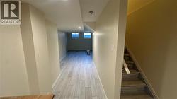 Interior space featuring wood-finish plank flooring, neutral wall paint, recessed lighting, and a staircase with coordinating wood-finish treads - 