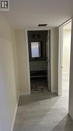 Wood-finish flooring throughout, bathroom featuring a vanity with under-counter storage, stone-patterned tile flooring, and a wall-mounted mirror - 