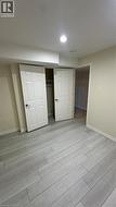 Neutral-toned wood-finish flooring, six-panel interior doors, and a built-in reach-in closet with overhead shelving - 