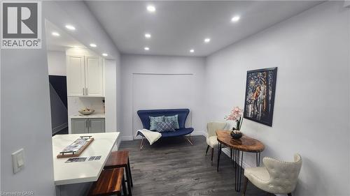 Open-concept space featuring recessed ceiling lighting, wood-finish flooring, and white cabinetry with a quartz countertop breakfast bar - 1394 Cannon Street E, Hamilton, ON 