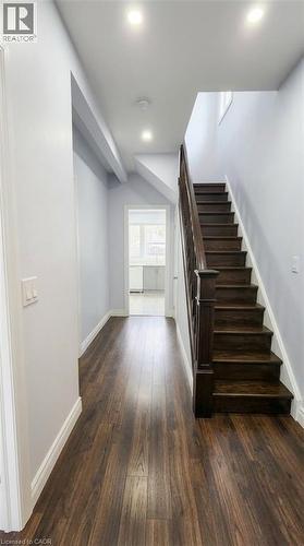 Hallway featuring dark wood-finish flooring, recessed lighting, and a staircase with stained wood treads and a coordinating handrail - 1394 Cannon Street E, Hamilton, ON 