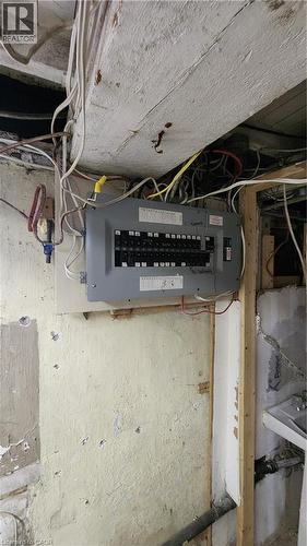 Electrical service panel mounted to wood framing with exposed interior wiring - 1394 Cannon Street E, Hamilton, ON 