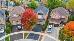 Multi-level homes featuring brick facades, asphalt shingle roofing, integrated double-car garages, and paved asphalt driveways - 