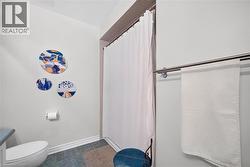 Bathroom featuring a tub-shower combination with full-height surround tiling and a metallic towel bar - 