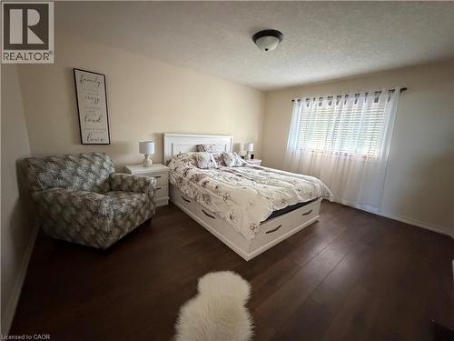 Room featuring wood-finish flooring, neutral wall tones, flush-mount ceiling lighting, and horizontal window blinds - 521 Snowdrop Court, Kitchener, ON 