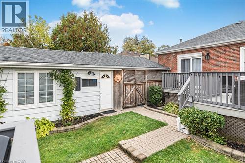 Red brick exterior, elevated wood deck, paver stone walkway, detached structure with white siding, and built-in privacy lattice fencing - 43 Alderney Avenue, Hamilton, ON 