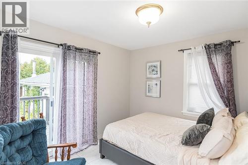 Neutral wall tones, sliding glass door with exterior deck access, and double-hung window with finished trim - 43 Alderney Avenue, Hamilton, ON 