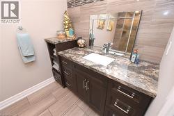 Dark wood-finish vanity with an integrated sink, polished chrome faucet, and a large wall-mounted mirror - 