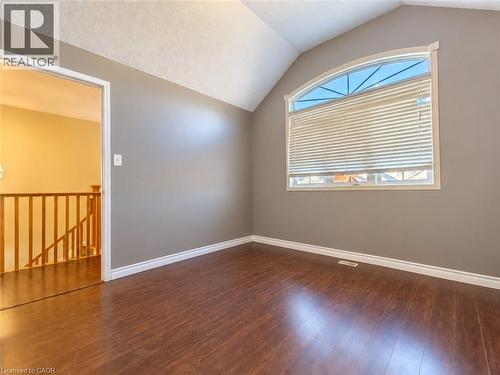 Vaulted ceiling featuring a fan-shaped arched window, wood-finish flooring, and neutral wall tones - 52 Isabella Street, Kitchener, ON 