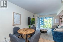 Living space featuring wood-finish flooring, floor-to-ceiling windows, and a decorative wall treatment - 