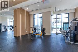 Fitness facility featuring floor-to-ceiling windows, vertical wood slat wall detailing with integrated LED accent lighting, and impact-resistant rubber flooring - 