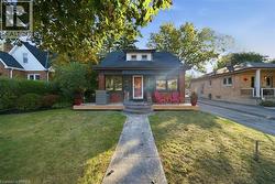 Brick exterior featuring a wood-finish front deck, arched stone entry steps, and a central dormer window - 