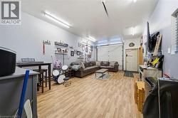 Finished garage space featuring wood-finish flooring, high-output LED overhead lighting, and an insulated sectional garage door - 