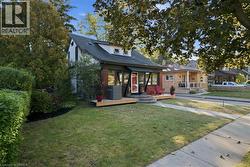 Two-story residence featuring a brick and siding exterior, front wood deck, stone steps, gabled roofline, and multi-pane front window configuration - 