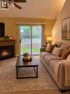 AI photo of livingroom and walkout to patio and a gas fireplace, vaulted ceiling, and ceiling fan - 