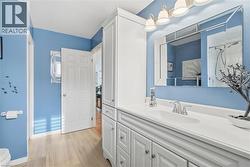 White shaker-style cabinetry with ample storage, integrated single-basin sink, and a mounted mirror with overhead lighting - 
