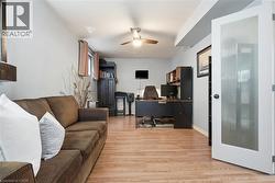Wood-finish flooring, ceiling fan with integrated lighting and a door with frosted glass paneling - 