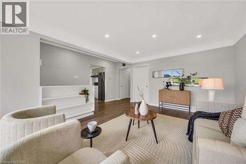 Recessed lighting, wood-finish flooring, half wall with shelving, gray wall tones, and white trim throughout - 284 Cedar Crescent, Cambridge, ON - Indoor Photo Showing Living Room