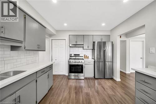 Kitchen featuring wood-finish flooring, recessed lighting, stainless steel appliances, grey cabinetry, and a white tile backsplash - 284 Cedar Crescent, Cambridge, ON - Indoor Photo Showing Kitchen With Upgraded Kitchen