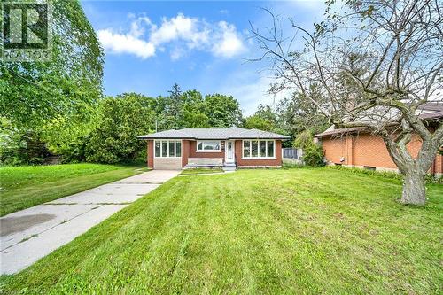 Brick exterior with white trim, a concrete driveway, and a front lawn - 284 Cedar Crescent, Cambridge, ON - Outdoor