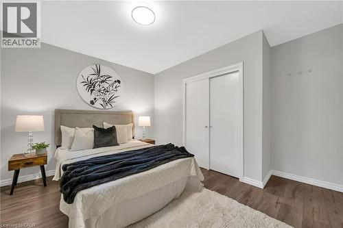 Recessed ceiling light fixture, sliding closet doors, wood-finish flooring, and white trim accents - 284 Cedar Crescent, Cambridge, ON - Indoor Photo Showing Bedroom