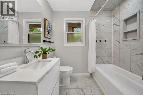 Contemporary vanity with an integrated rectangular sink, chrome faucet, and illuminated mirror - 284 Cedar Crescent, Cambridge, ON - Indoor Photo Showing Bathroom
