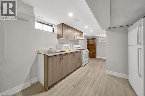 Recessed lighting, wood-finish flooring, wood-finish cabinetry, built-in stove, and built-in refrigerator - 284 Cedar Crescent, Cambridge, ON - Indoor Photo Showing Kitchen