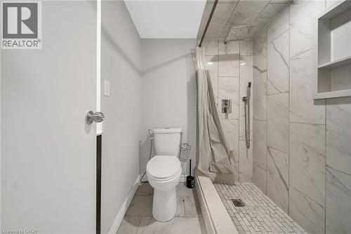 Walk-in shower with large format wall tiling, rain shower head, and built-in shelving - 284 Cedar Crescent, Cambridge, ON - Indoor Photo Showing Bathroom