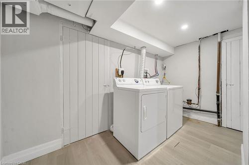 Wood-finish flooring with recessed ceiling lights - 284 Cedar Crescent, Cambridge, ON - Indoor Photo Showing Laundry Room