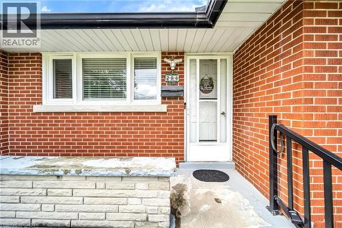 Brick exterior with white window trim, a white storm door, and a black handrail - 284 Cedar Crescent, Cambridge, ON - Outdoor With Exterior