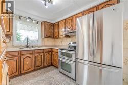 Kitchen featuring wood cabinetry, light-toned countertops, and a tile backsplash - 