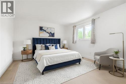 Bright interior featuring wood-finish flooring, white baseboards, and a large window with white trim - 1259 Ernest Avenue, London, ON - Indoor Photo Showing Bedroom