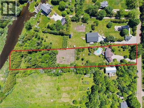 Expansive property featuring a curved swimming pool, multiple outbuildings, wooded areas, and a visible river boundary - 5779 Third Line, Guelph/Eramosa, ON - Outdoor With View