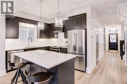 Kitchen with stainless steel appliances, a breakfast bar, light wood finished floors, a kitchen island, and pendant lighting - 239 Cranbrook Street, Kitchener, ON - Indoor Photo Showing Kitchen With Upgraded Kitchen