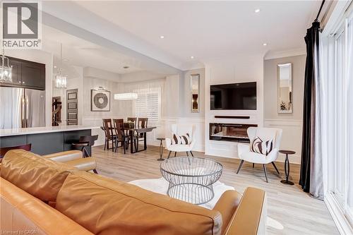 Living room with a decorative wall, a wainscoted wall, light wood finished floors, and recessed lighting - 239 Cranbrook Street, Kitchener, ON - Indoor Photo Showing Living Room With Fireplace