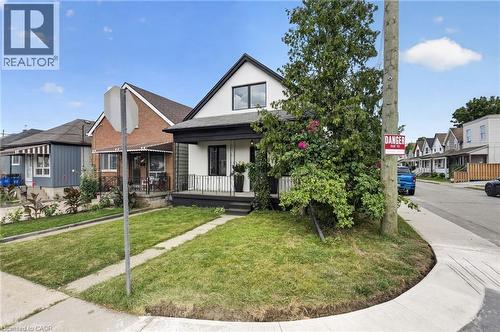 White facade with black trim, a gabled roof, and a covered porch - 174 London Street N, Hamilton, ON - Outdoor