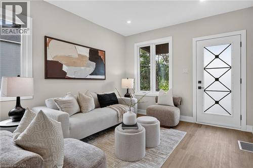 Wood-finish flooring, recessed lighting, and a decorative frosted glass entry door - 174 London Street N, Hamilton, ON - Indoor Photo Showing Living Room