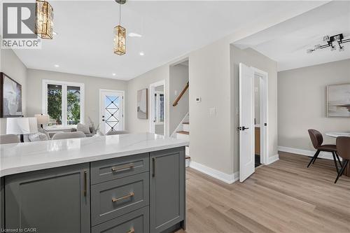Kitchen island with a white countertop and gray cabinetry - 174 London Street N, Hamilton, ON - Indoor Photo Showing Dining Room