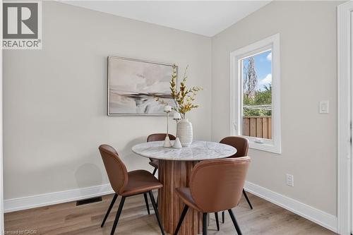 Light-toned wall paint, wood-finish flooring, white trim, and a white-framed window - 174 London Street N, Hamilton, ON - Indoor Photo Showing Bathroom
