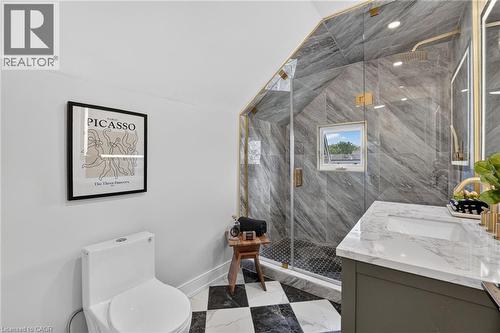 Glass-enclosed shower with gray stone-look wall tile and gold-tone fixtures - 174 London Street N, Hamilton, ON - Indoor Photo Showing Bathroom