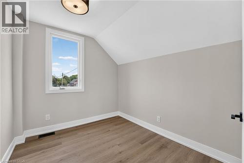 Wood-finish flooring, white trim, and a window with white casing - 174 London Street N, Hamilton, ON - Indoor Photo Showing Other Room