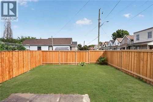 Expansive backyard with a manicured lawn, surrounded by a complete privacy fence - 174 London Street N, Hamilton, ON - Outdoor