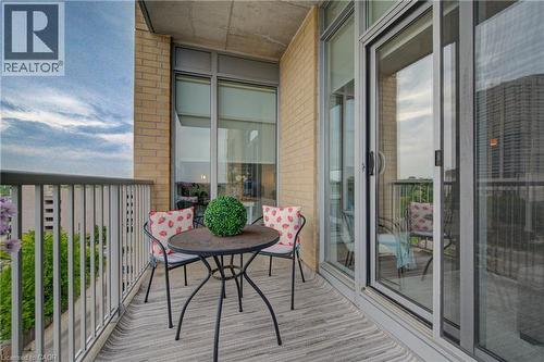 Private balcony featuring a light grey textured floor, painted metal railing, and brick exterior - 191 King Street S Unit# 607, Waterloo, ON - Outdoor With Balcony With Exterior