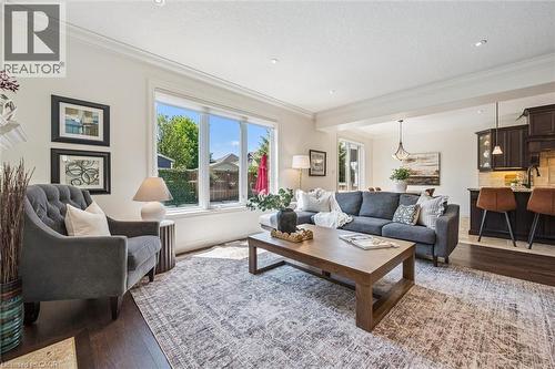 Spacious living area featuring large windows, dark wood-finish flooring, recessed lighting, and crown molding. - 828 Copper Ridge Drive, Waterloo, ON - Indoor Photo Showing Living Room